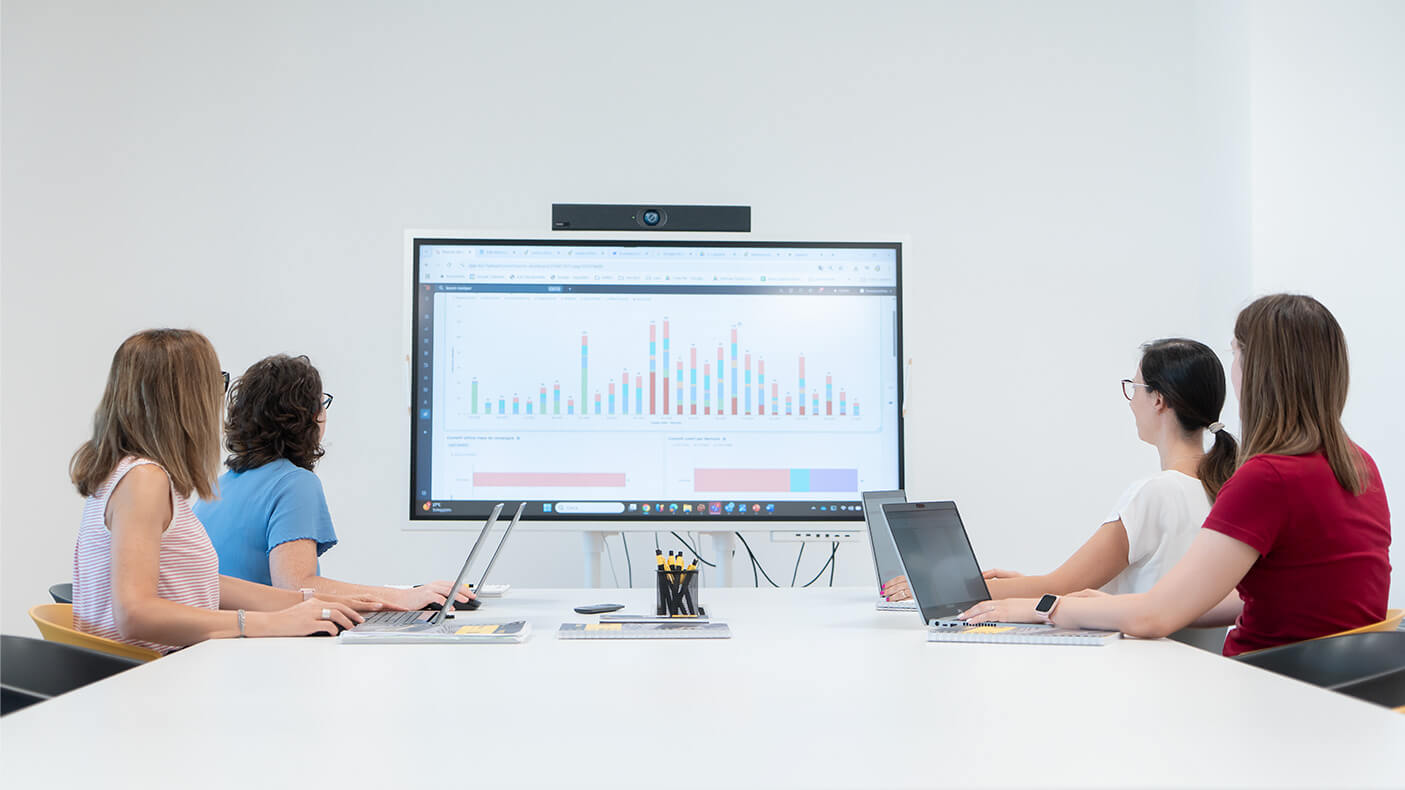 Euromacchine sales. Office team analyzing business data on a large screen during meeting.
