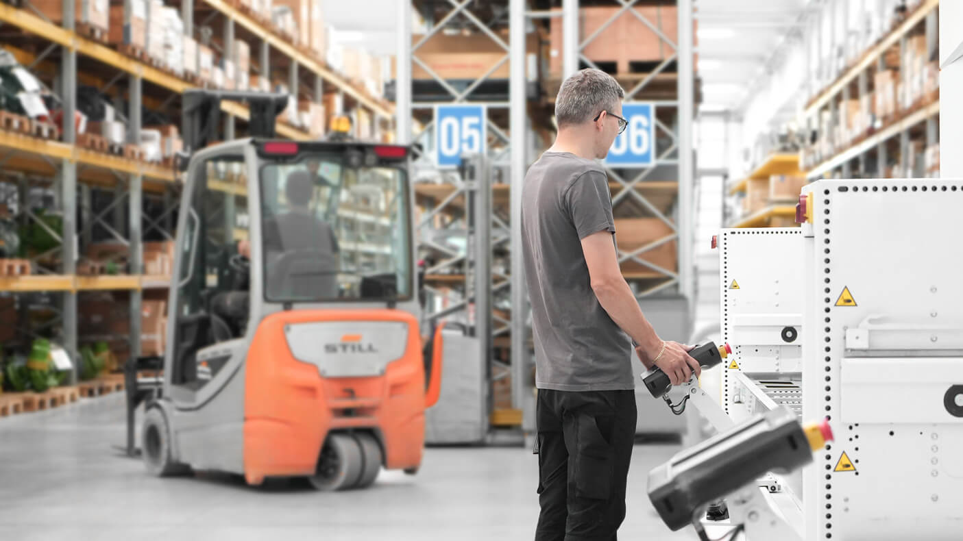 Euromacchine warehouse. Worker operating machinery in Euromacchine warehouse with forklift nearby.